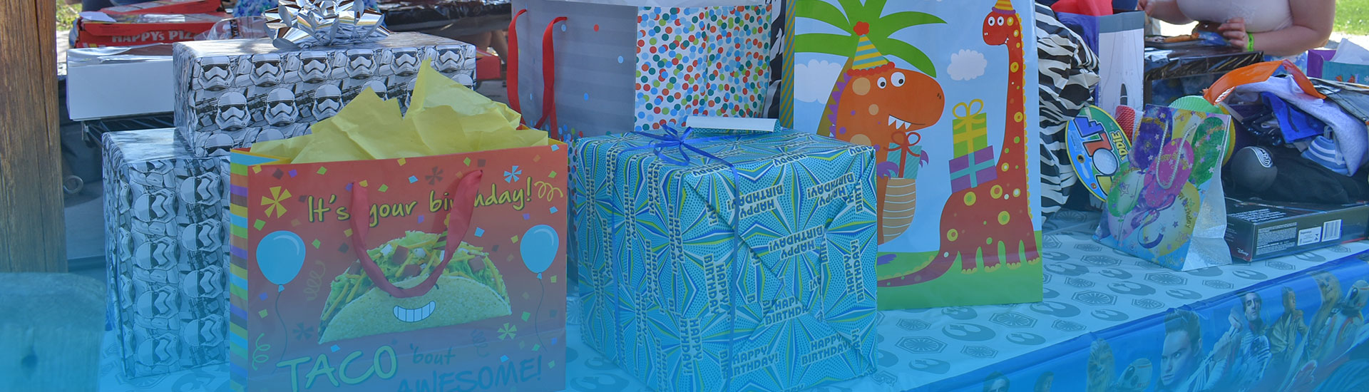 Birthday presents in bags and wrapping paper on a table